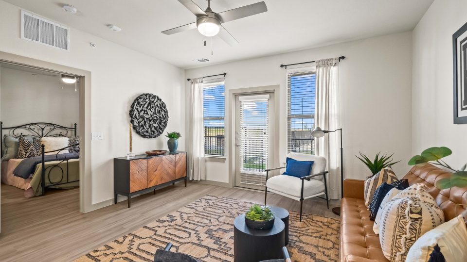 the living room has a ceiling fan and a large window at The La Ventana